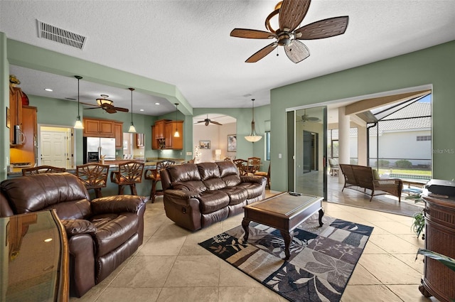 tiled living room featuring a textured ceiling