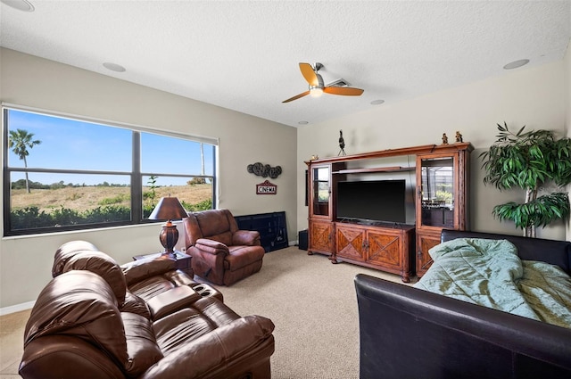 carpeted living room featuring a textured ceiling and ceiling fan