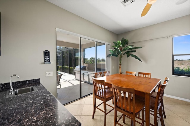 tiled dining room with ceiling fan and sink