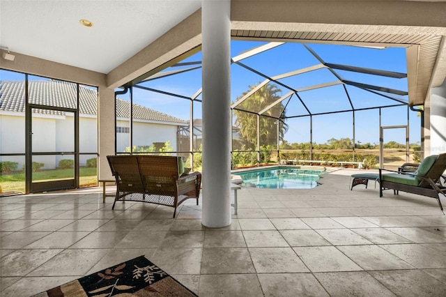 view of pool featuring glass enclosure and a patio area