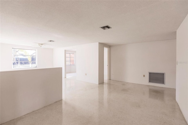 unfurnished room featuring ceiling fan and a textured ceiling