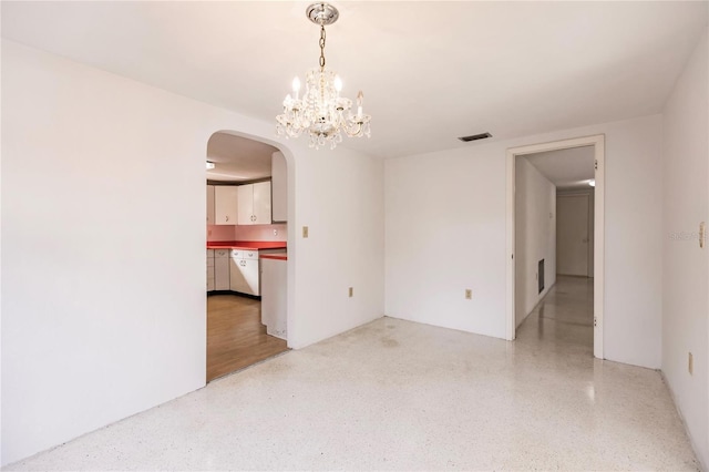 unfurnished room with a chandelier