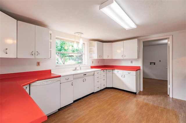 kitchen with white cabinets, dishwasher, sink, and light hardwood / wood-style flooring