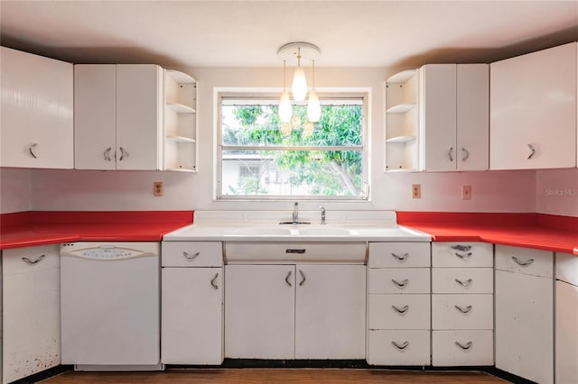 kitchen with white dishwasher, pendant lighting, white cabinetry, and sink