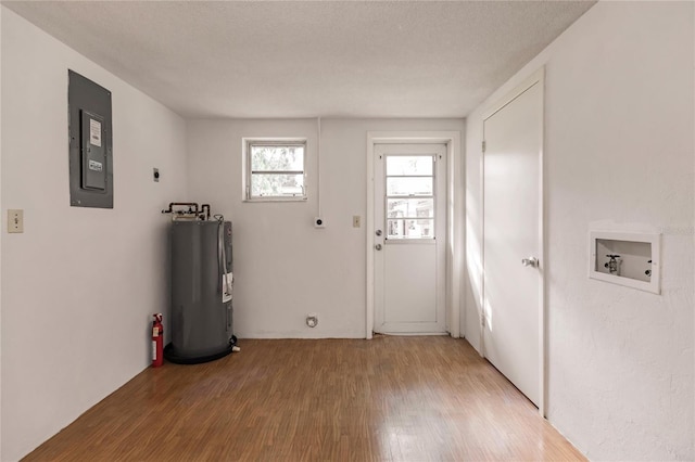 entryway with a textured ceiling, electric panel, hardwood / wood-style flooring, and water heater