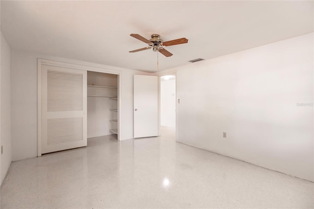 unfurnished bedroom with ceiling fan and a closet