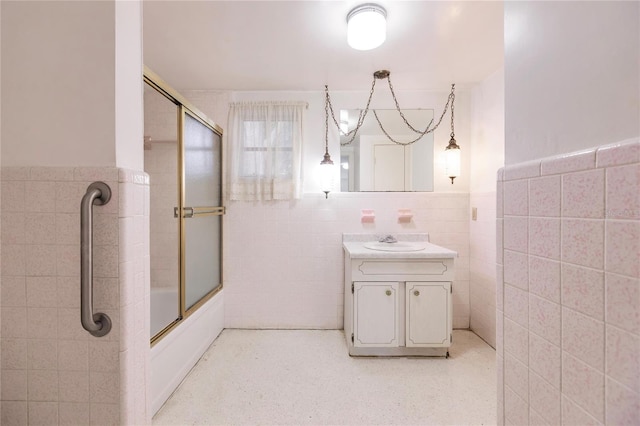 bathroom with vanity, enclosed tub / shower combo, and tile walls