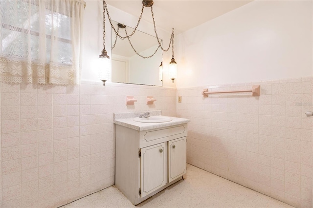 bathroom featuring vanity and tile walls