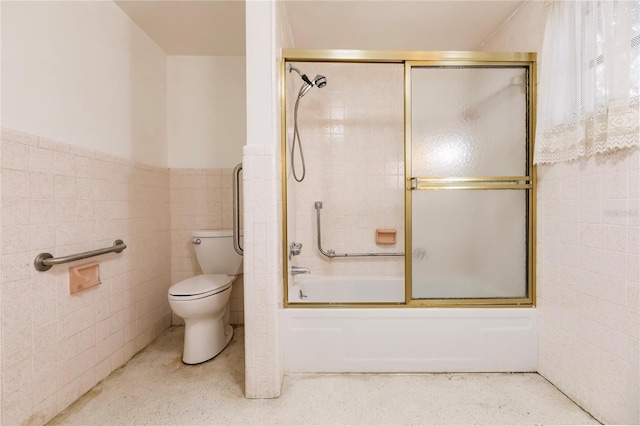 bathroom with bath / shower combo with glass door, tile walls, and toilet