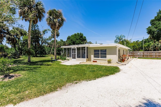 view of front facade featuring a front yard and a sunroom