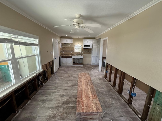 unfurnished living room with ceiling fan, dark hardwood / wood-style flooring, and ornamental molding