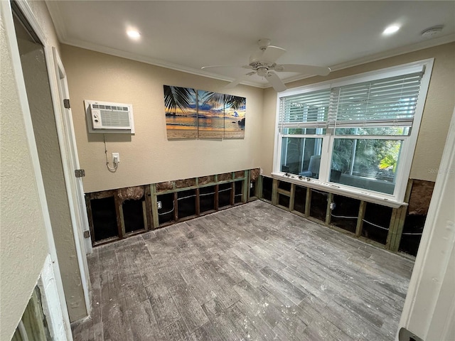 spare room featuring hardwood / wood-style flooring, ceiling fan, an AC wall unit, and crown molding