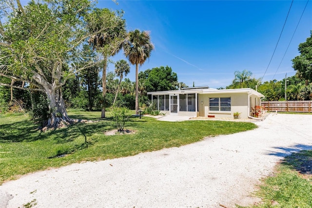 view of front of property featuring a front yard and a sunroom