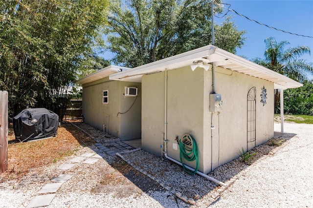 view of side of home featuring a wall mounted air conditioner