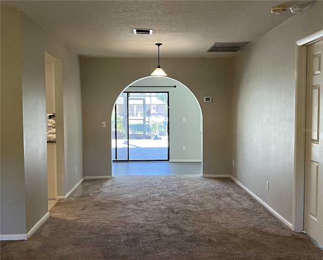 unfurnished dining area featuring carpet floors and a textured ceiling