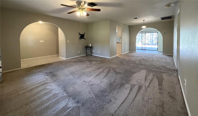 1196 Hinton St, Port Charlotte, FL 33952 - carpeted empty room with arched walkways and a ceiling fan