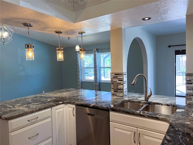 kitchen with pendant lighting, sink, stainless steel dishwasher, tasteful backsplash, and white cabinetry