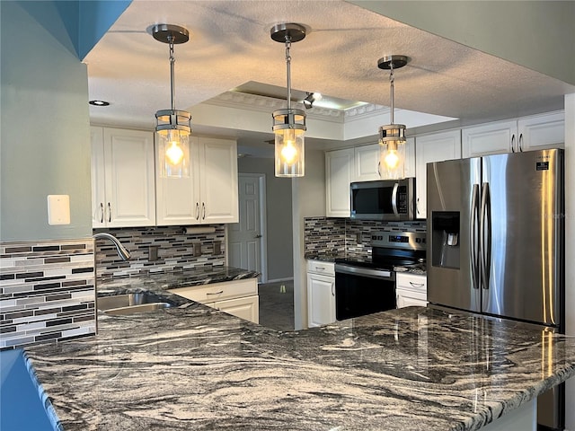 1196 Hinton St, Port Charlotte, FL 33952 - kitchen with stainless steel appliances, tasteful backsplash, white cabinetry, a peninsula, and a textured ceiling