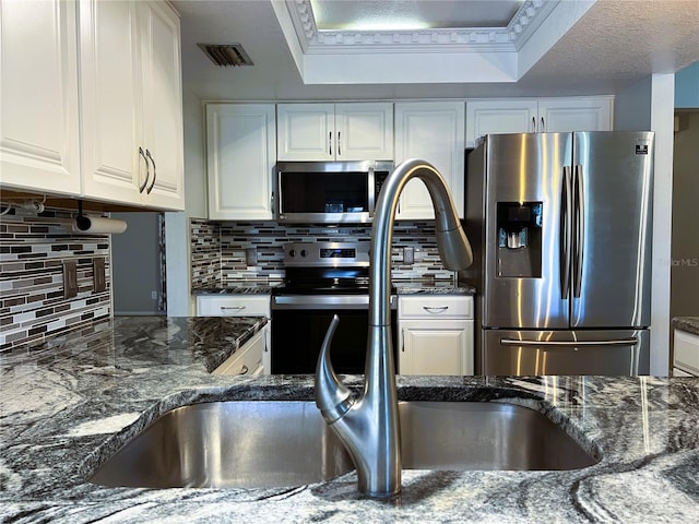 1196 Hinton St, Port Charlotte, FL 33952 - kitchen featuring appliances with stainless steel finishes, white cabinetry, tasteful backsplash, and dark stone countertops