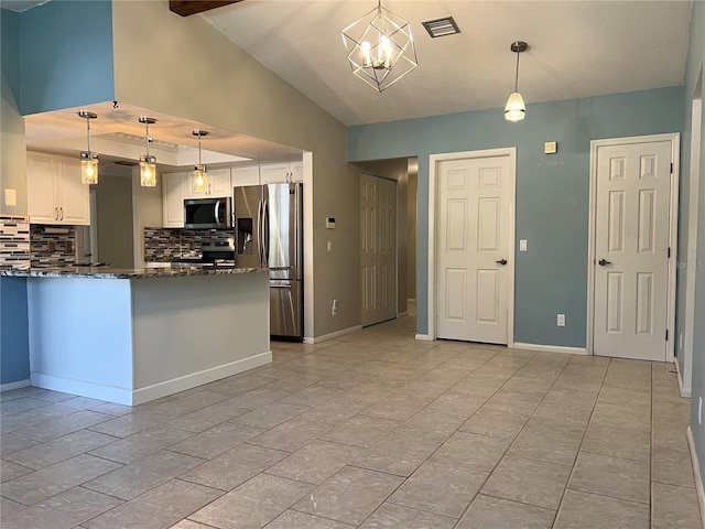 kitchen with white cabinetry, hanging light fixtures, dark stone counters, decorative backsplash, and appliances with stainless steel finishes