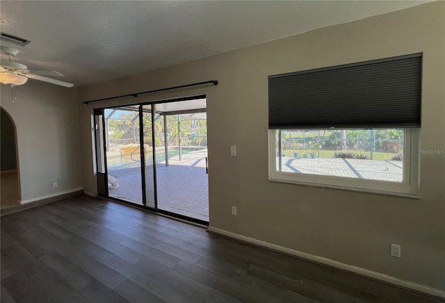 unfurnished room with ceiling fan, a healthy amount of sunlight, and dark hardwood / wood-style flooring