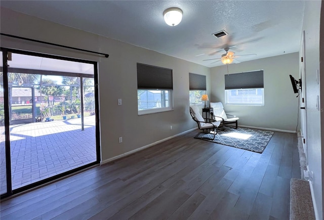 unfurnished room with ceiling fan, wood-type flooring, and a textured ceiling