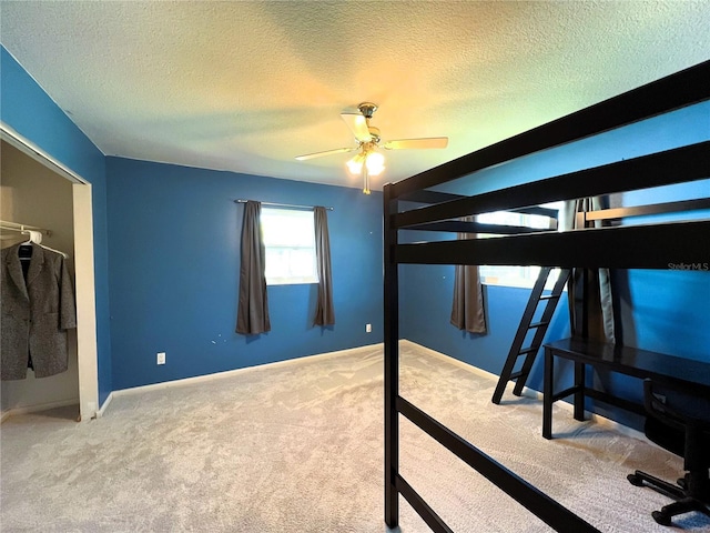 unfurnished bedroom featuring light carpet, a textured ceiling, and ceiling fan