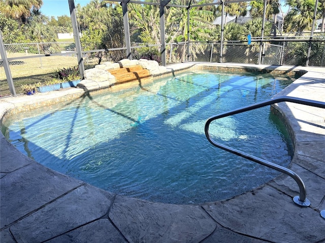 view of swimming pool featuring glass enclosure