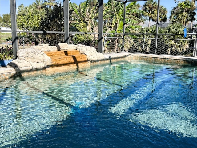 view of pool featuring glass enclosure