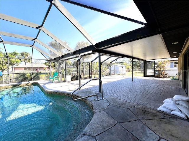 view of swimming pool featuring glass enclosure and a patio