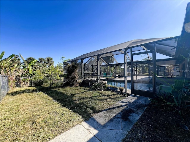 view of yard with glass enclosure and a water view