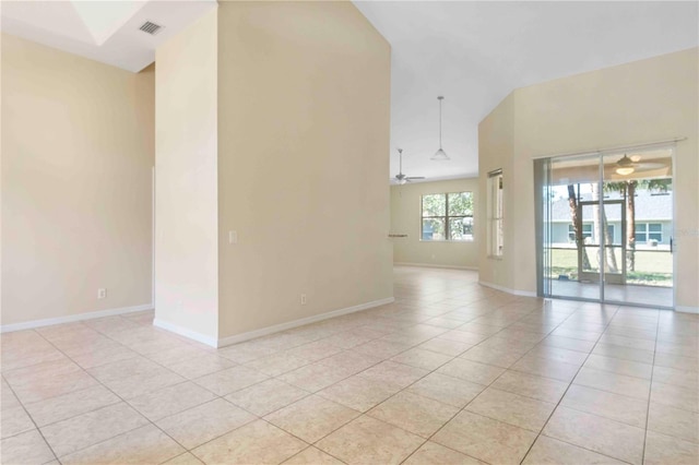 tiled empty room with ceiling fan and high vaulted ceiling