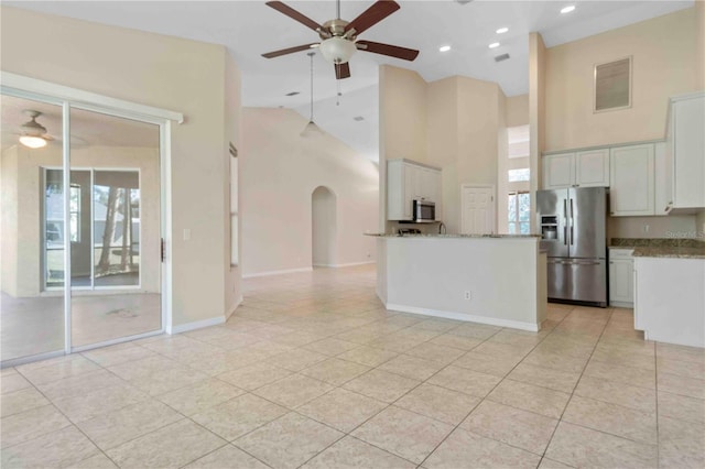 kitchen featuring high vaulted ceiling, white cabinets, ceiling fan, light stone countertops, and stainless steel appliances