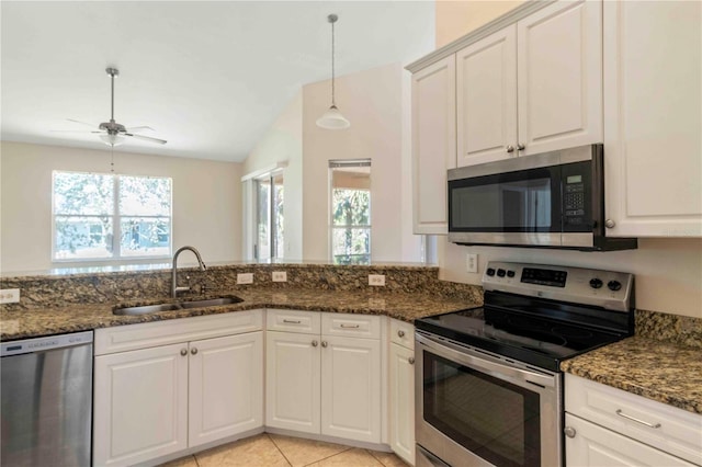 kitchen with sink, white cabinetry, stainless steel appliances, and dark stone counters