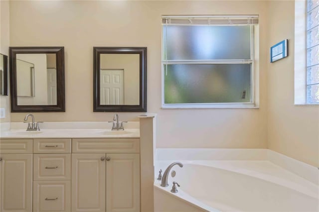 bathroom with vanity and a bath