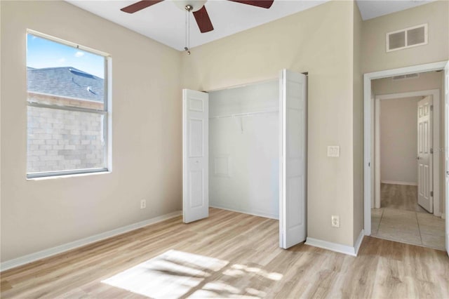 unfurnished bedroom with ceiling fan, light wood-type flooring, and a closet