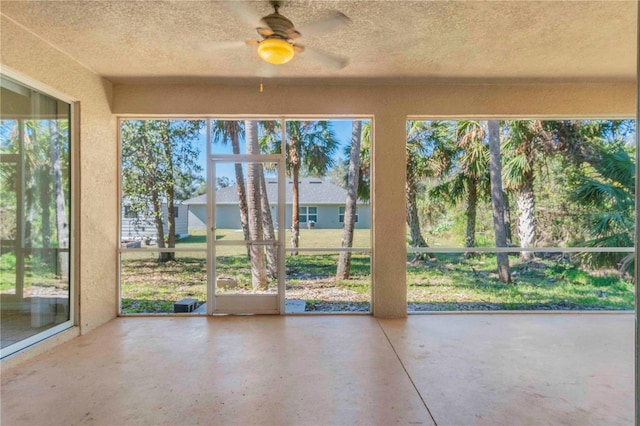 unfurnished sunroom with ceiling fan