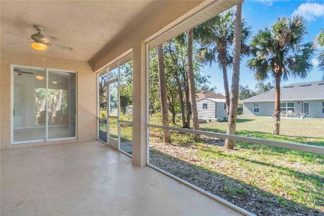 unfurnished sunroom with ceiling fan