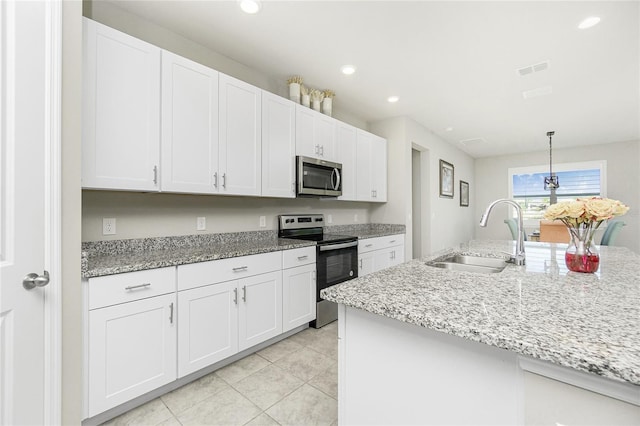 kitchen with hanging light fixtures, white cabinetry, sink, and stainless steel appliances