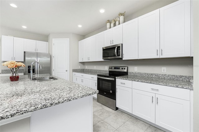 kitchen featuring white cabinets, light stone counters, sink, and appliances with stainless steel finishes