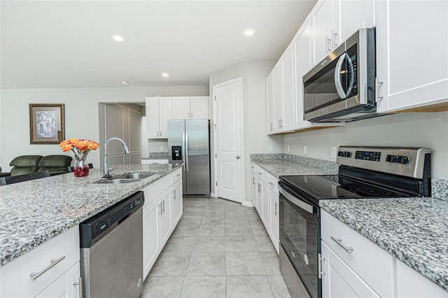 kitchen with light stone countertops, white cabinetry, sink, and appliances with stainless steel finishes