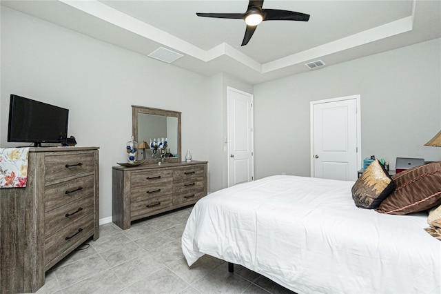 bedroom featuring a raised ceiling, ceiling fan, and light tile patterned floors