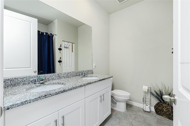 bathroom with tile patterned flooring, vanity, and toilet