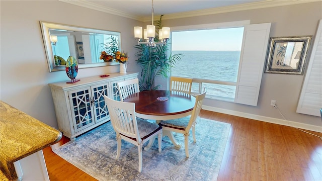 dining room with a water view, hardwood / wood-style flooring, and a healthy amount of sunlight