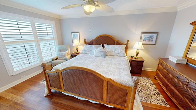 bedroom featuring dark hardwood / wood-style flooring, ceiling fan, and crown molding