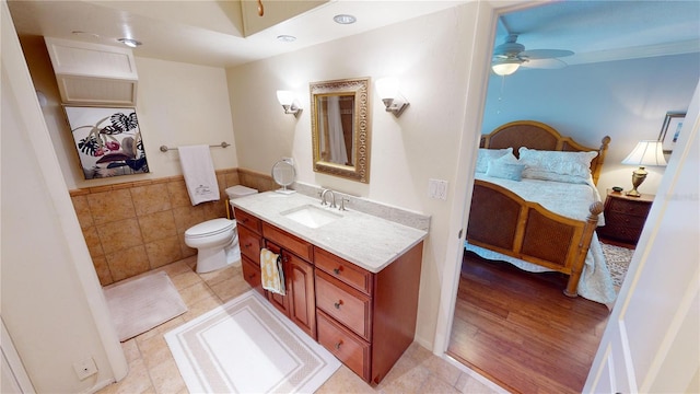 bathroom with hardwood / wood-style floors, ceiling fan, toilet, and vanity