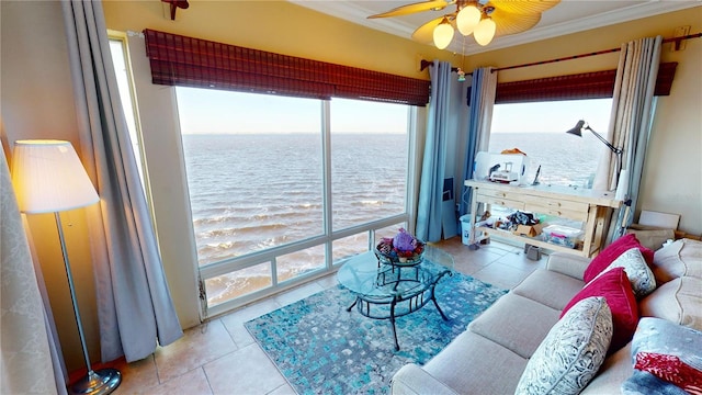 living room with a wealth of natural light, crown molding, a water view, and light tile patterned floors