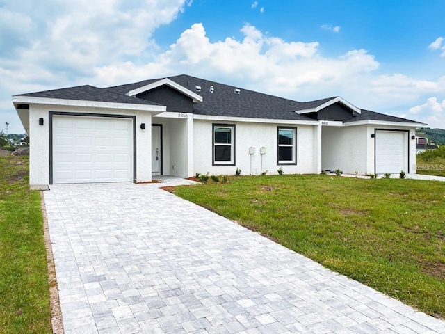 single story home featuring a front yard and a garage