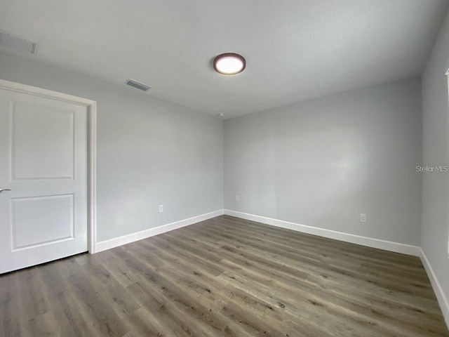 unfurnished room featuring dark wood-type flooring