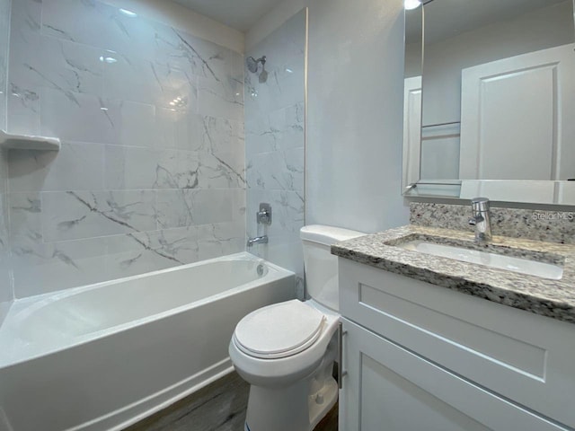 full bathroom featuring hardwood / wood-style floors, vanity, toilet, and tiled shower / bath combo